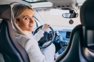 Eine Frau sitzt in einem Auto und schaut über die Schulter nach hinten - MPU Beratung Marburg